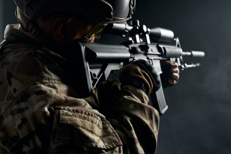 Old soldier in uniform pointing with sniper rifle.